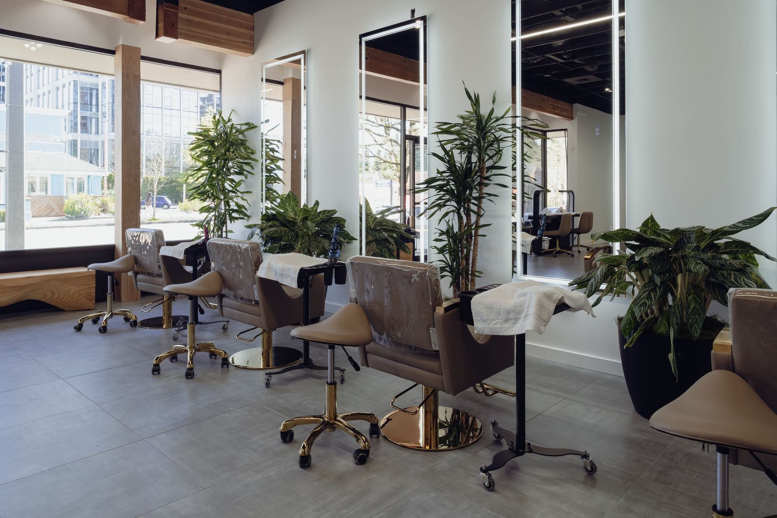 Row of styling stations beside floor-to-ceiling windows