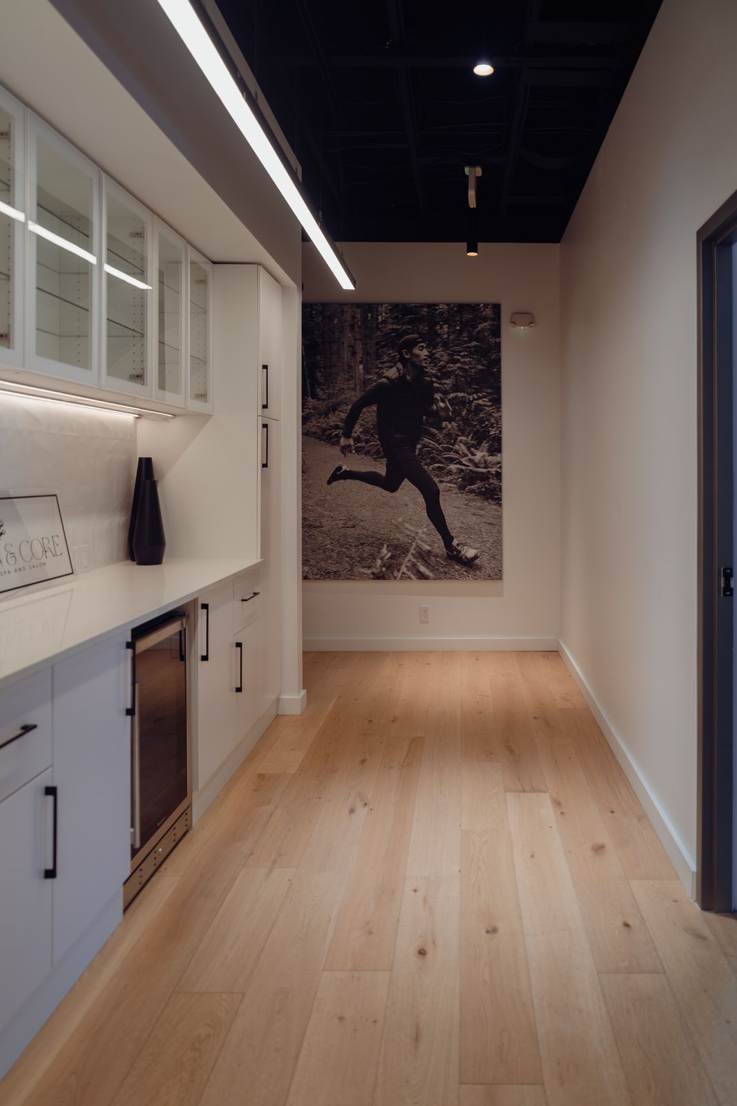 Hallway with a refreshment bar and a large black-and-white trail runner print